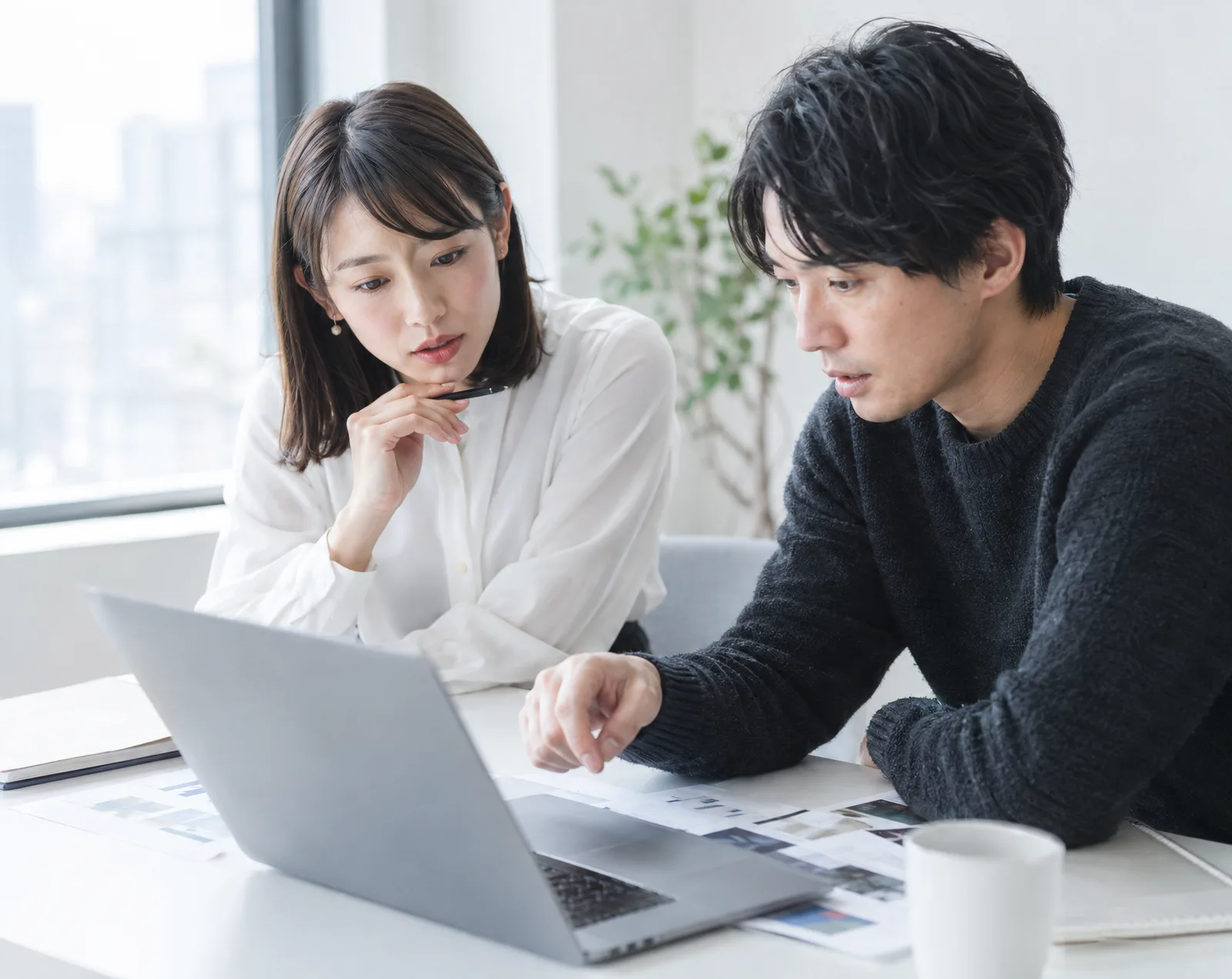 打ち合わせ中の二人が資料をのぞき込んでいる様子